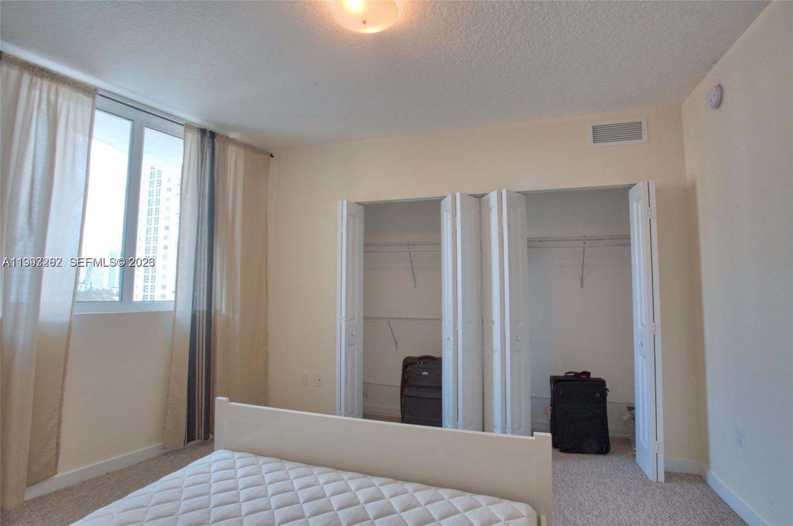 601 Northeast 23rd Street, Unit 1004 Miami, FL 33137 - Photo 10 of 17 a bedroom with a bed and a window