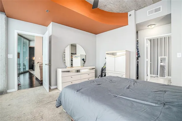 a large bedroom with a large bed and chandelier