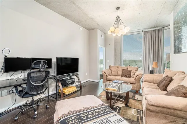 a living room with furniture a flat screen tv and a window