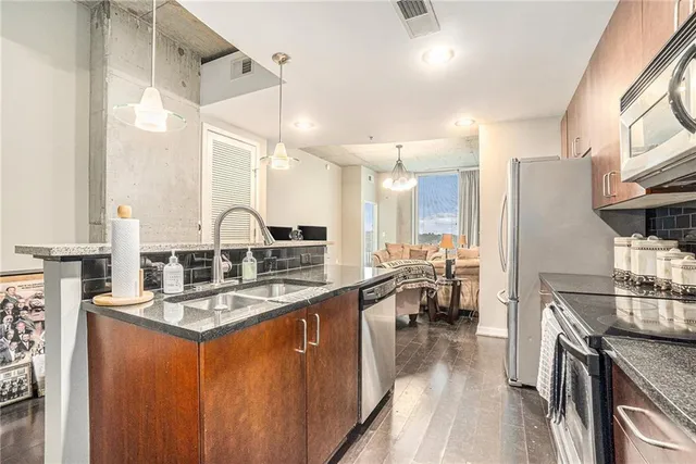 a kitchen with stainless steel appliances granite countertop a sink stove and refrigerator