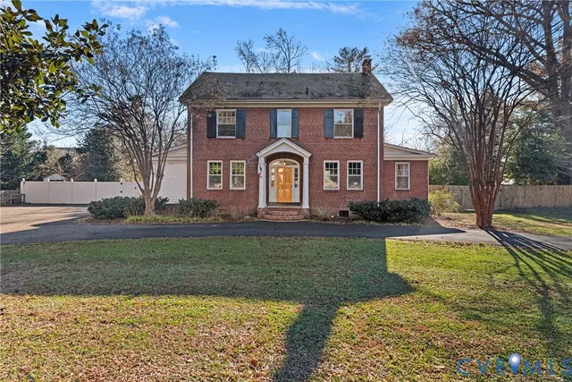 a view of a house next to a yard with big trees