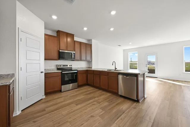 a kitchen with granite countertop a stove top oven and cabinets