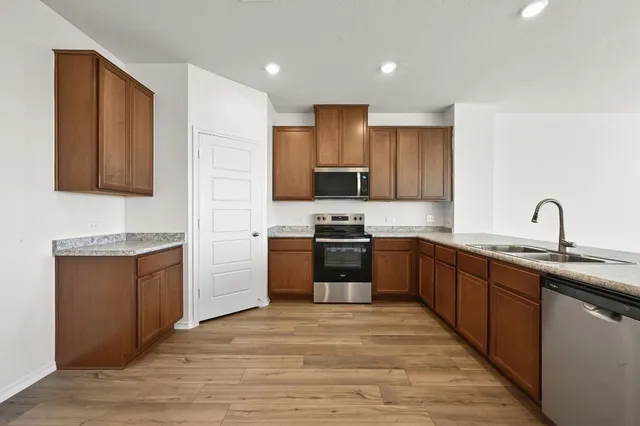 a kitchen with stainless steel appliances granite countertop a sink stove and refrigerator