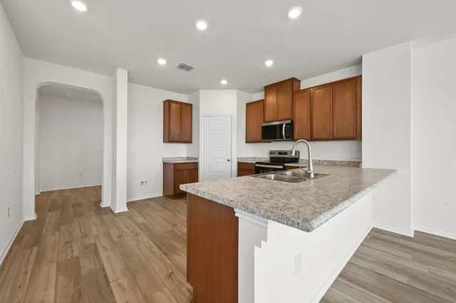 a kitchen with a sink refrigerator and microwave