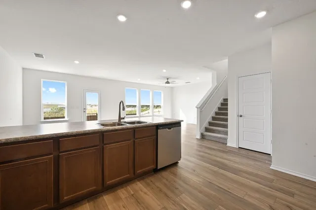 a kitchen with wooden floors wooden cabinets and entryway