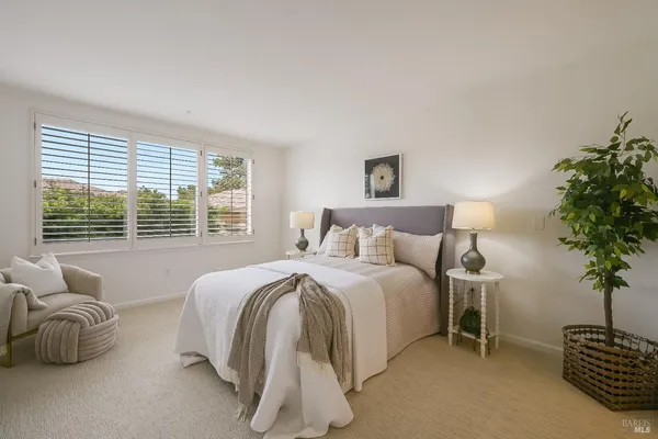 a spacious bedroom with a bed and a potted plant