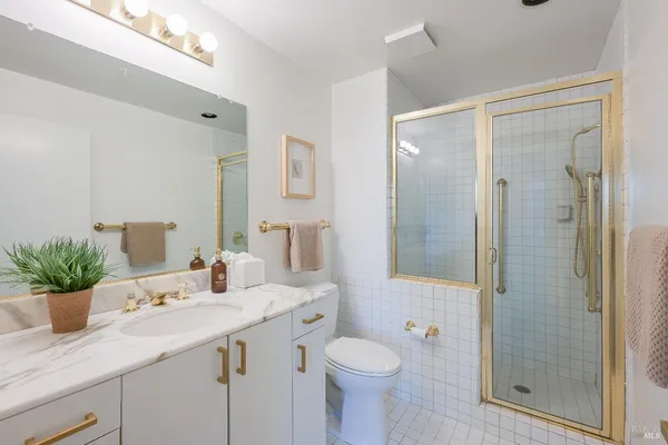 a bathroom with a sink a toilet and shower