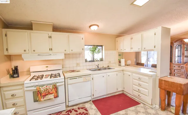 a kitchen that has a lot of cabinets in it and wooden floors