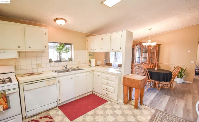 a dining room with furniture a chandelier and wooden floor