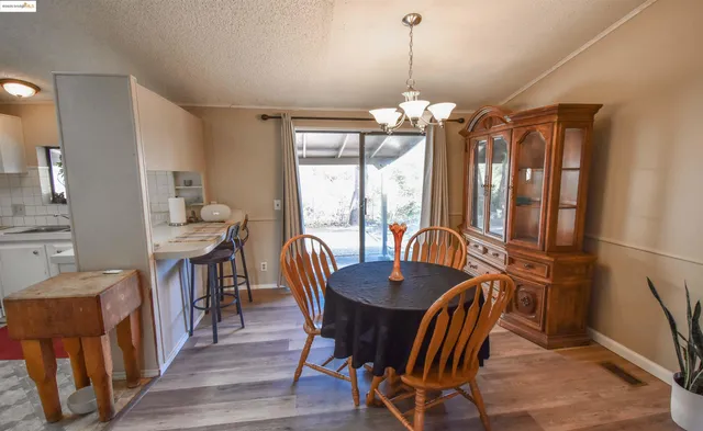 a living room with furniture a flat screen tv and a refrigerator