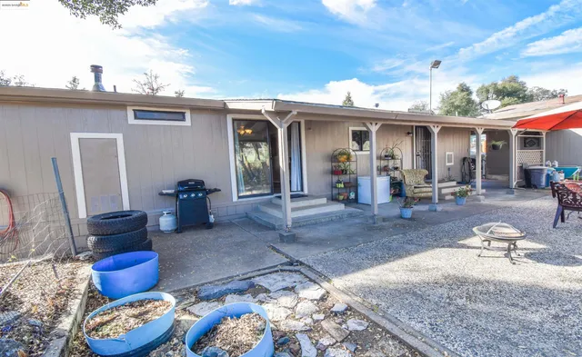 a view of a house with backyard sitting area and furniture