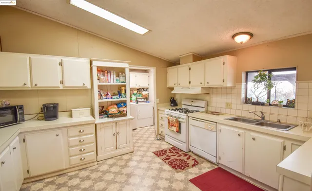 a kitchen with white cabinets sink and white appliances