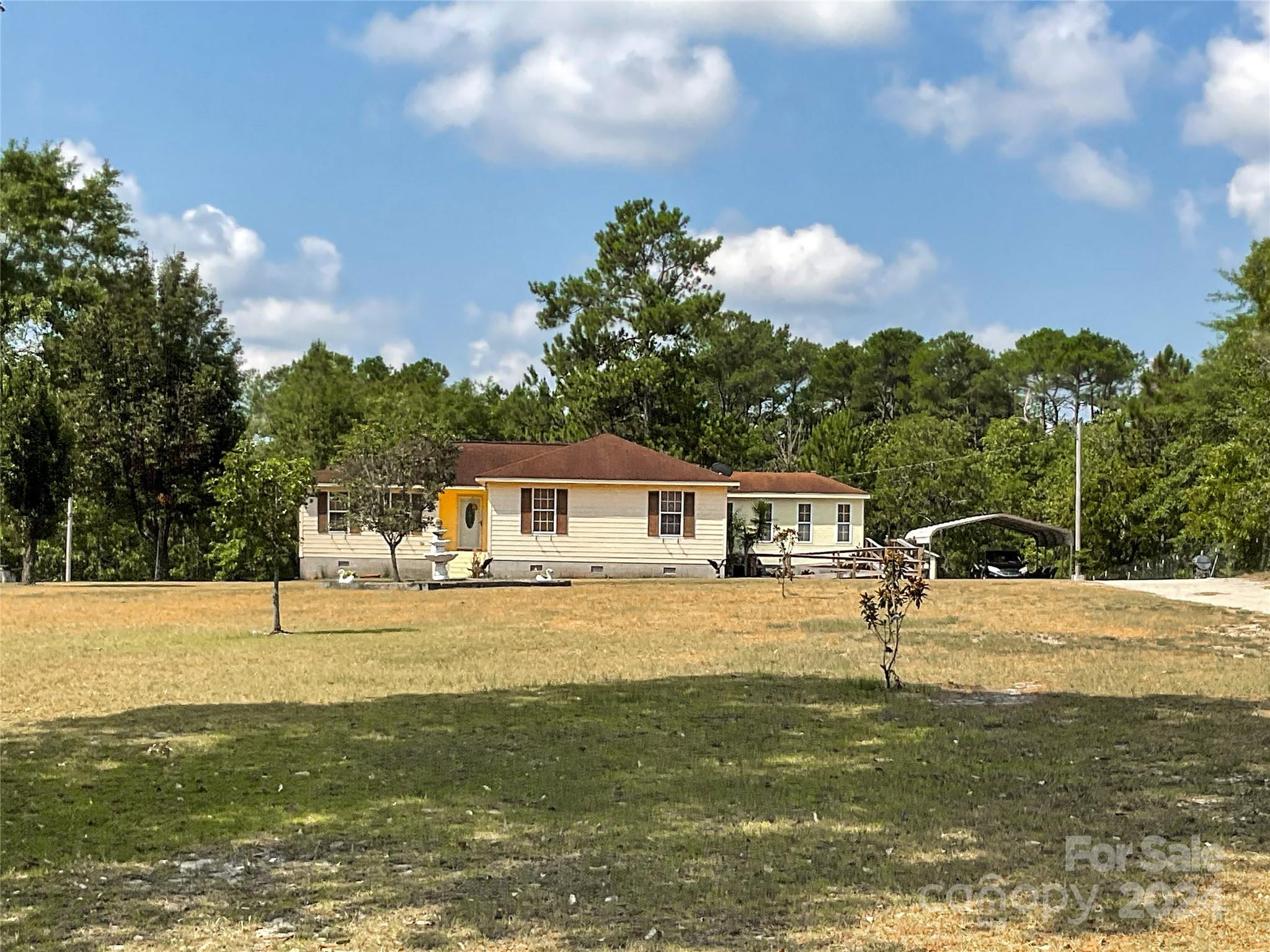 267 Homeplace Road Rockingham, NC 28379 - Photo 46 of 47 a house view with a swimming pool and trees in the background