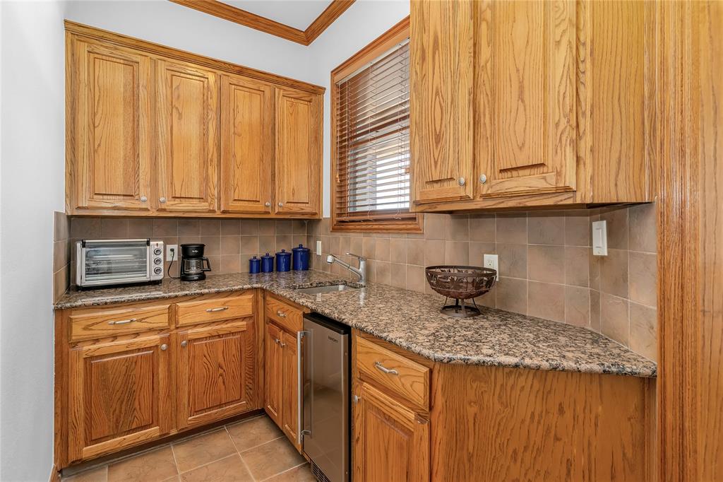 4520 South Nolan River Road Cleburne, TX 76033 - Photo 11 of 40 Kitchen featuring a sink, tasteful backsplash, ornamental molding, and a toaster