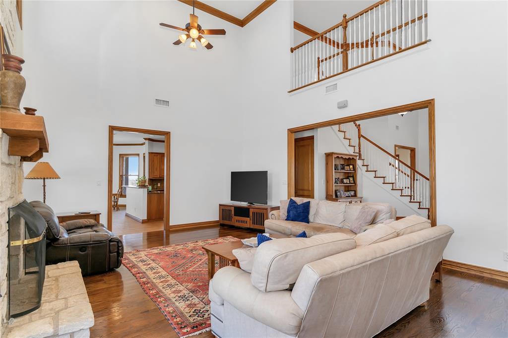 4520 South Nolan River Road Cleburne, TX 76033 - Photo 24 of 40 Living room with ceiling fan, visible vents, wood finished floors, and stairs