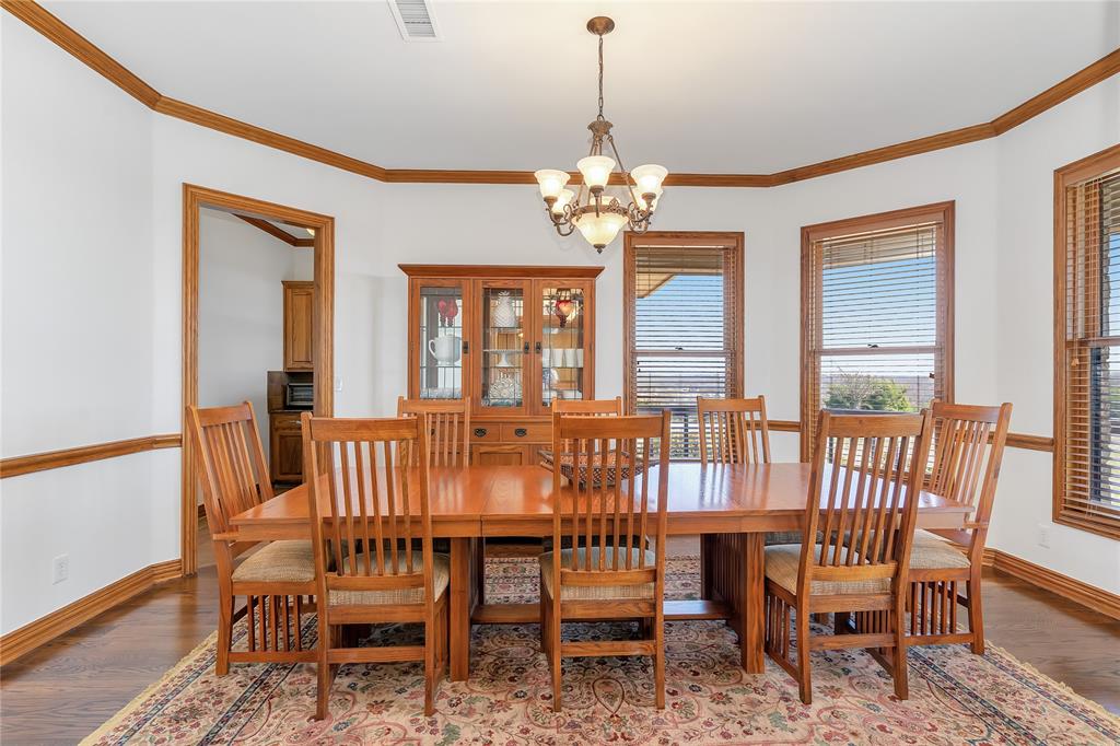 4520 South Nolan River Road Cleburne, TX 76033 - Photo 9 of 40 Dining area featuring crown molding, baseboards, light wood-type flooring, and a chandelier
