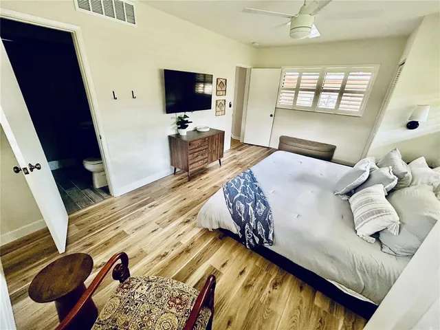 a bedroom with a bed window and a flat screen tv