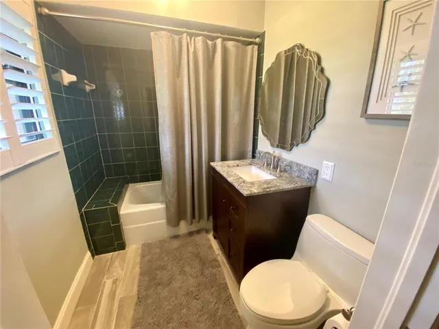 a bathroom with a sink a toilet a mirror and shower