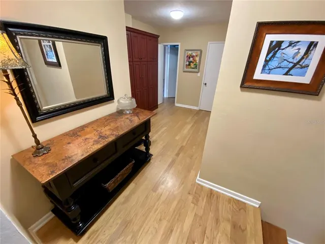 a room with wooden floor and paintings on the wall