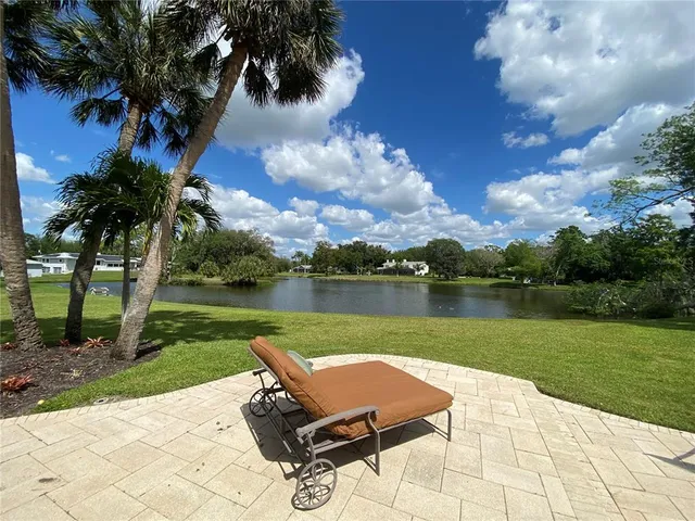 a view of a lake with a yard and a patio