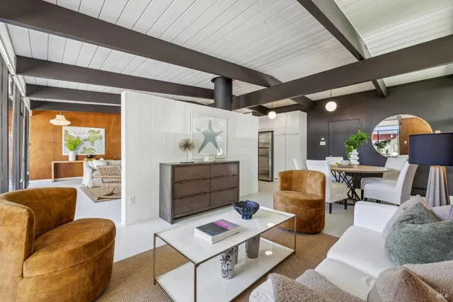 a living room with furniture a rug and a table
