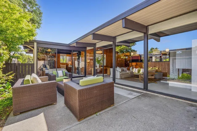 a view of a patio with a table and chairs under an umbrella