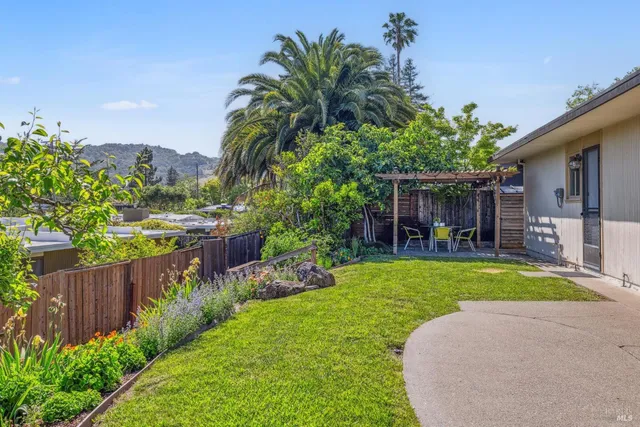 a view of a chair and table in backyard of the house