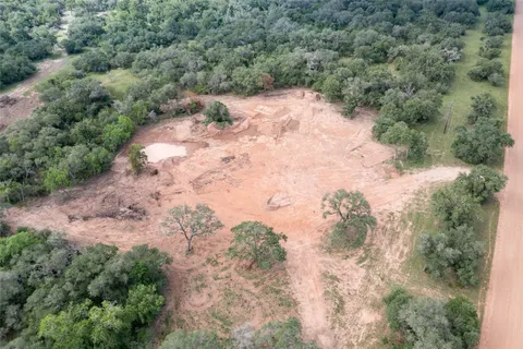 a view of a dry yard with trees