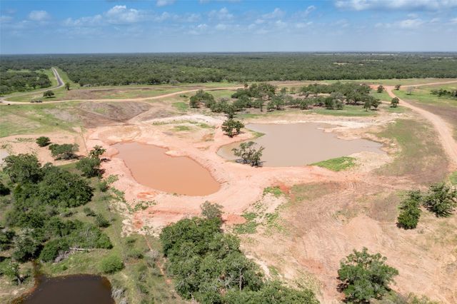 an aerial view of residential houses with outdoor space and trees