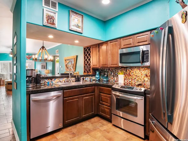 a kitchen with stainless steel appliances granite countertop a refrigerator a stove top oven a sink and dishwasher