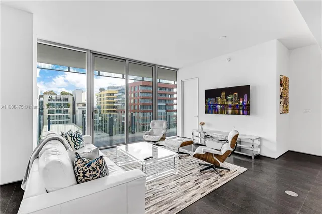 a living room with furniture floor to ceiling window and wooden floor