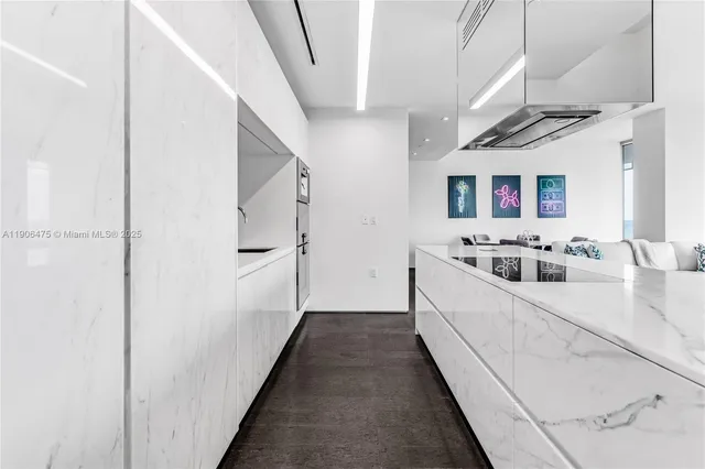 a large white kitchen with sink and refrigerator