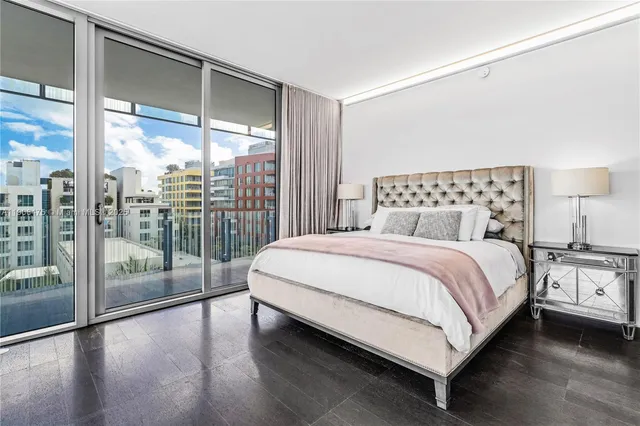 a bedroom with a large bed and a large window with outer view