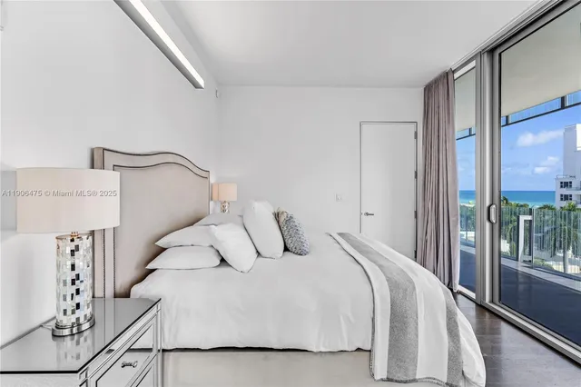 a bedroom with a bed and a large mirror next to a large window