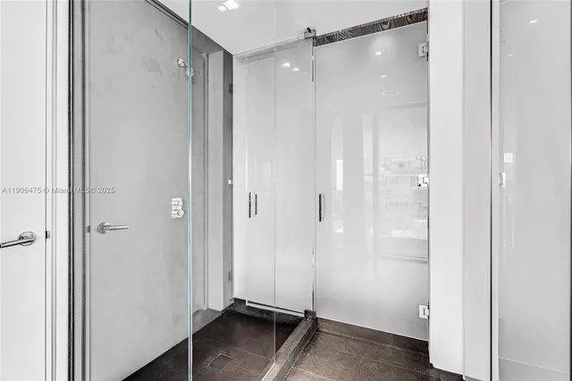 a bathroom with a shower and a glass door