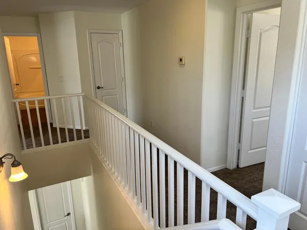 a view of a hallway with wooden floor and staircase
