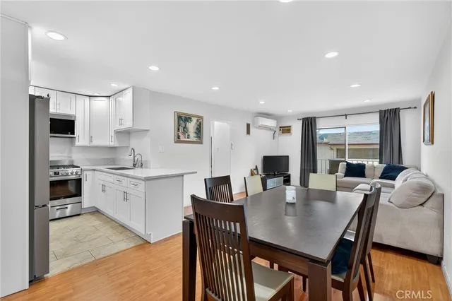 a kitchen with granite countertop a table chairs a sink dishwasher refrigerator and cabinets