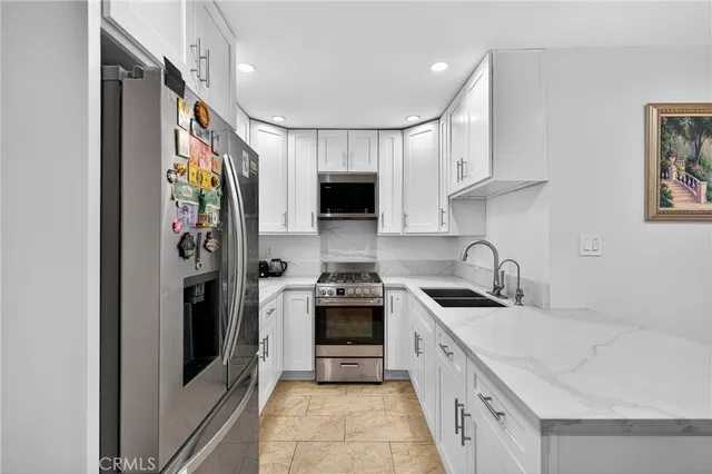 a kitchen with stainless steel appliances granite countertop a sink stove and refrigerator
