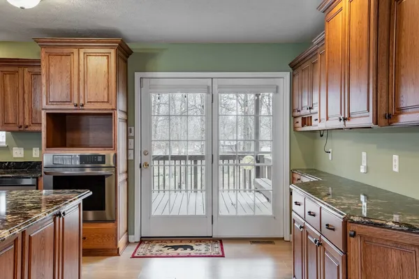 a kitchen with granite countertop a stove a sink and a microwave