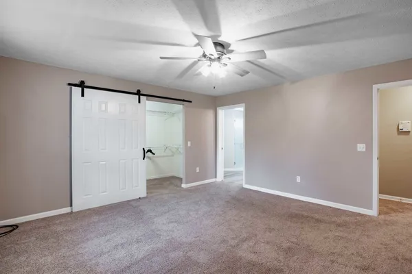 a view of an empty room and chandelier fan