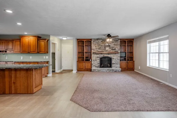 an empty room with windows and fireplace