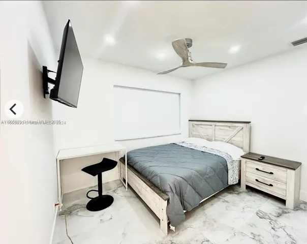 a bedroom with a bed and a ceiling fan