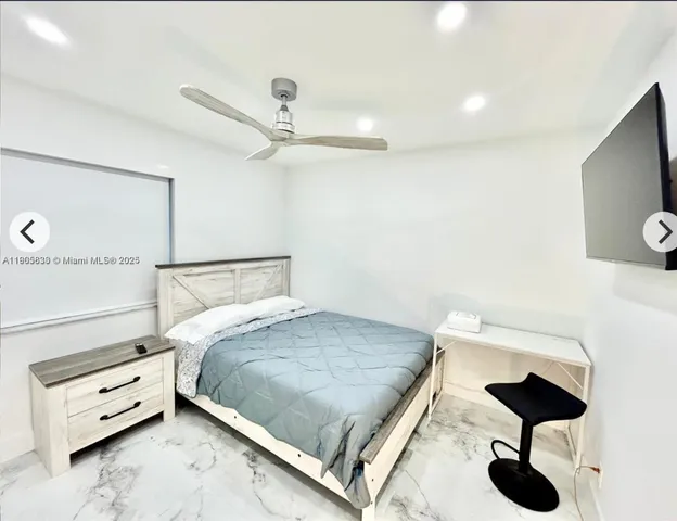 a bedroom with a bed and a flat tv screen