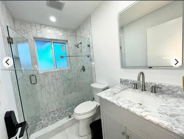 a bathroom with a granite countertop sink toilet and shower