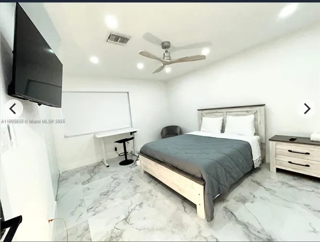 a bedroom with a bed and a flat screen tv
