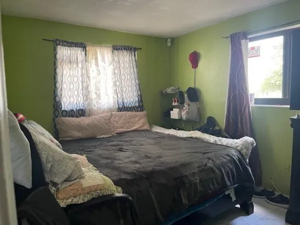 a bedroom with a bed and a window