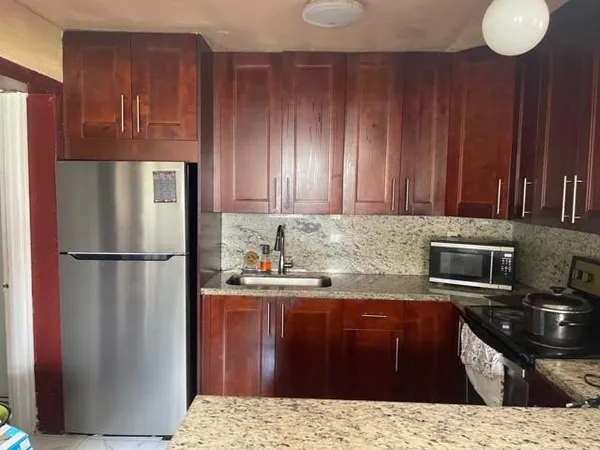 a kitchen with a refrigerator sink and cabinets