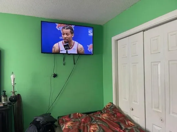 a bedroom with a bed and a painting on the wall