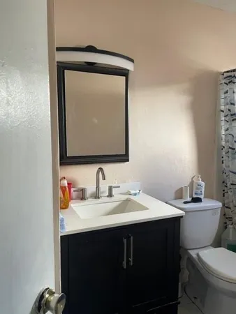 a bathroom with a toilet sink and mirror