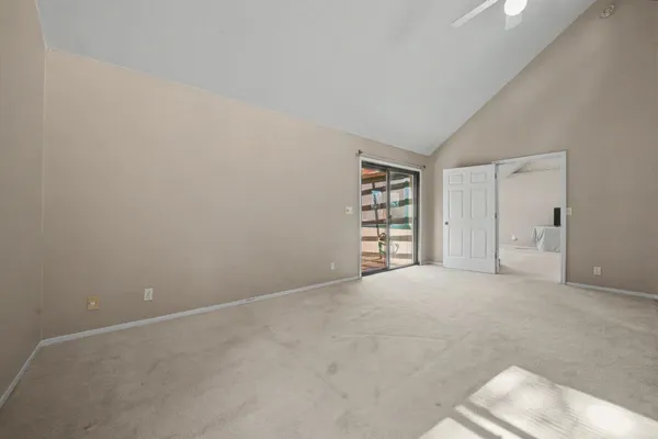 an empty room with fan and windows